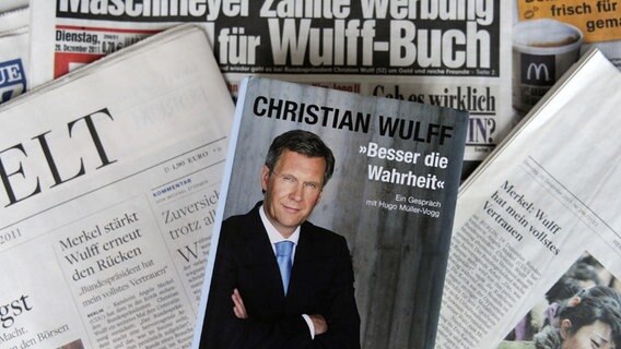 Christian Wulffs Buch "Besser die Wahrheit" liegt auf verschiedenen Zeitungen, die die Wulff-Affäre thematisieren. © dpa-Bildfunk / picture alliance Foto: Holger Hollemann