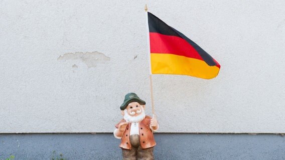 Ein Gartenzwerg hält eine Deutschland-Fahne in der Hand. © picture alliance/dpa Foto: Julian Stratenschulte