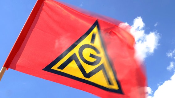 Eine Fahne der Gewerkschaft IG-Metall weht vor blauem Himmel. © dpa-Bildfunk Foto: Daniel Bockwoldt/dpa