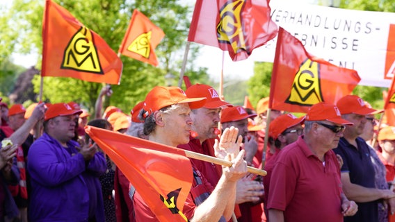 Mehrere Menschen nehmen mit roten Flaggen der Gewerkschaft IG Metall an einer Veranstaltung teil. © IG Metall 