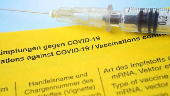 Eine Spritze liegt auf einem Impfausweis. © picture alliance/CHROMORANGE | Christian Ohde Foto: Christian Ohde