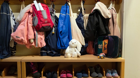 Kinderjacken und Schuhe an einer Garderobe einer Kindertagesstätte. © dpa Foto: Friso Gentsch