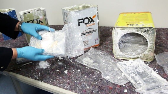 Ein Zollbeamter präsentiert Kokain, das auf einem Tisch im Zollfahndungsamt liegt. © picture alliance/dpa Foto: Bodo Marks