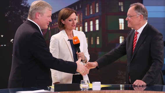 Der Spitzenkandidat der CDU, Bernd Althusmann (l) und Niedersachsens Ministerpräsident Stephan Weil (SPD) reichen sich im Fernsehstudio des ZDF für den Wahlabend in Hannover bei Bettina Schausten die Hand. © dpa Foto: Christian Charisius