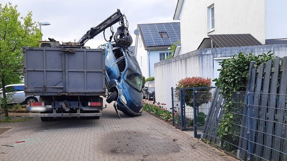Ein Auto hängt von der Greifschaufel eines Ladekrans. © Polizeiinspektion Celle 
