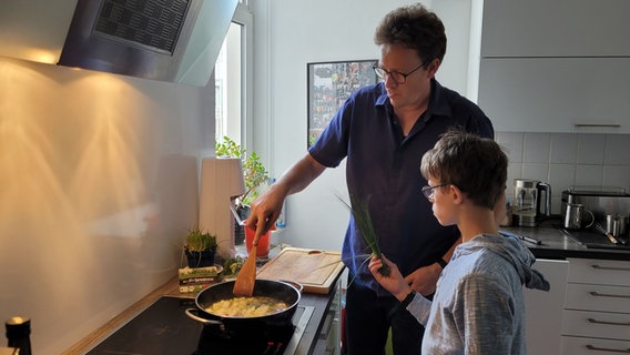 Ein Mann und ein Junge kochen zusammen. © NDR Foto: Helene Buscholz