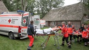 Sanitäter bringen eine verletzte Person auf einer Trage zu einem Rettungswagen. ©  dpa-Bildfunk Foto: Christian Butt