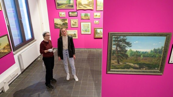 Daniela Sannwald und Nele Kröger betrachten Bilder der Ausstellung "Hey Heide" in der Kunsthalle Lüneburg. © dpa-Bildfunk Foto: Philipp Schulze