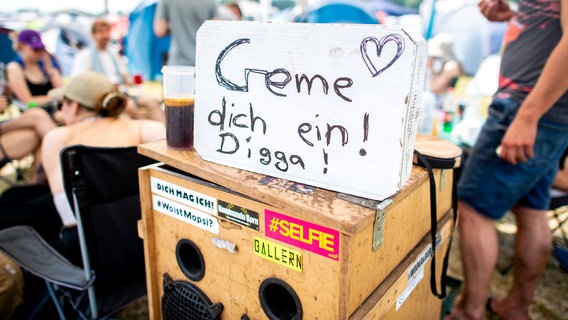 Auf einer Musikbox steht ein Schild mit den Worten "Creme dich ein! Digga!". © Hauke-Christian Dittrich/dpa Foto: Hauke-Christian Dittrich