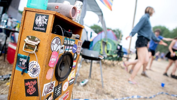 Eine Musikanlage steht auf dem Zeltplatz des Hurricane Festivals, während Besucherinnen zur Musik tanzen. © dpa-Bildfunk Foto: Hauke-Christian Dittrich