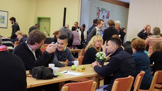 Mehrere Menschen sitzen an Tischen. © NDR Foto: Andreas Rabe