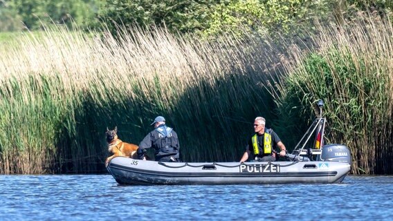 Einsatzkräfte der Polizei fahren bei der Suche nach dem vermissten Arian mit Spürhunden auf einem Schlauchboot über die Oste. © Sina Schuldt/dpa Foto: Sina Schuldt
