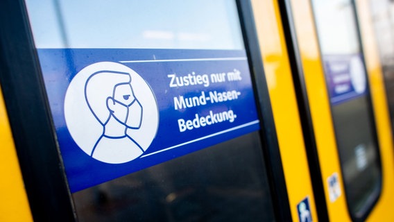 Ein Schild mit der Aufschrift "Zustieg nur mit Mund-Nasen-Bedeckung" klebt an der Zugtür einer Regio-S-Bahn der NordWestBahn im Oldenburger Hauptbahnhof. © dpa Foto: Hauke-Christian Dittrich