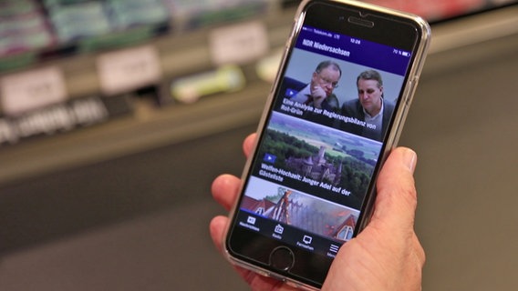 Ein Smartphone mit der geöffneten NDR App wird in der Hand gehalten. © NDR Foto: Thomas Hans