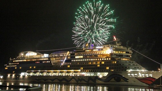 Die "AIDAStella" liegt in der Nacht im Hafenbecken der Papenburger Meyer Werft. Ein Feuerwerk am Himmel. © NDR Foto: Oliver Gressieker