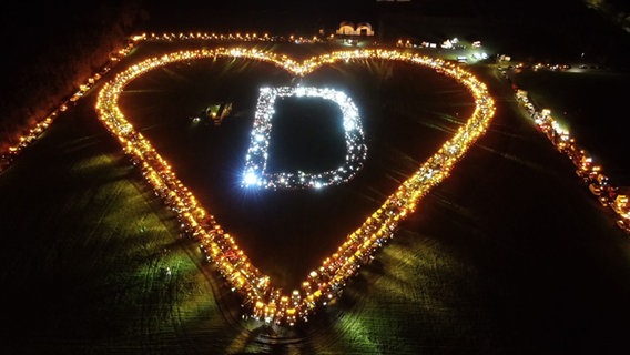 Aus Traktoren wurde ein Herz geformt. Darin leuchtet der Buchstabe "D". © Ehler Foto: Ehler