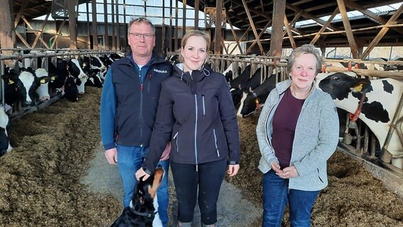 Landwirtin Jana Eilers steht mit ihren Eltern in einem Kuhstall. © NDR Foto: Birgit Stamerjohanns