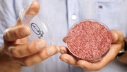 Ein Wissenschaftler hält eine Petrischale mit Kunstfleisch in den Händen. © dpa - Picture Alliance Foto: David Parry