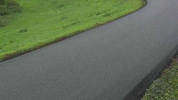 Der sogenannter Flüsterasphalt für Fahrräder auf einem Deichweg in Weyhe (Landkreis Diepholz). © NDR 