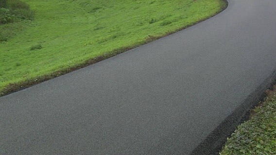 Der sogenannter Flüsterasphalt für Fahrräder auf einem Deichweg in Weyhe (Landkreis Diepholz). © NDR 