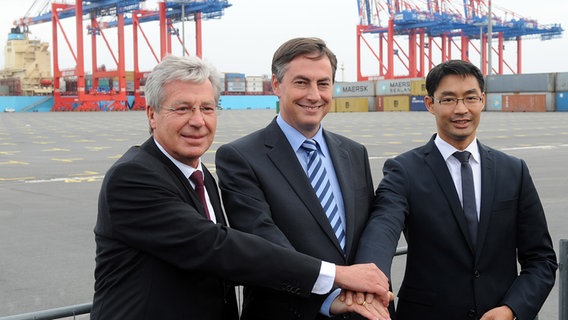 Bremens Regierungschef Jens Böhrnsen (SPD), Niedersachsens Ministerpräsident David McAllister (CDU) und Bundeswirtschaftsminister Philipp Rösler (FDP) (v.l.n.r.) legen bei der Eröffnung des JadeWeserPorts am 21. September 2012 in Wilhelmshaven die Hände aufeinander. Bremens Regierungschef Jens Böhrnsen (SPD), Niedersachsens Ministerpräsident David McAllister (CDU) und Bundeswirtschaftsminister Philipp Rösler (FDP) (v.l.n.r.) legen bei der Eröffnung des JadeWeserPorts am 21. September 2012 in Wilhelmshaven die Hände aufeinander. © picture alliance / dpa Foto: Ingo Wagner