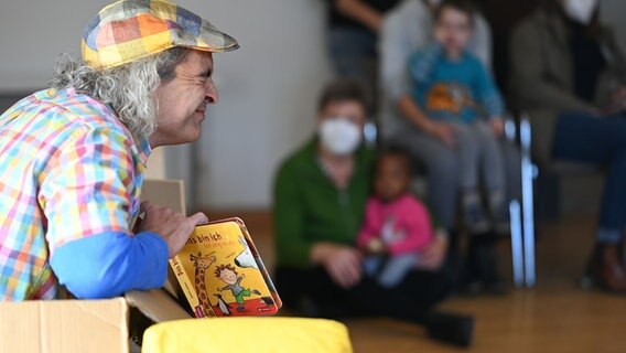 Bücher-Clown Armin liest und spielt Kindern etwas vor. © picture alliance/dpa/Lars Klemmer Foto: Lars Klemmer