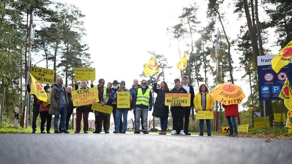 Gelbe Schilder gegen "Geschäfte mit Rosatom" und mit der Aufschrift "Kein Geld für Putins Krieg" werden von zwei Protestierenden in Lingen in den Händen gehalten. © Lars Klemmer/dpa Foto: Lars Klemmer/dpa