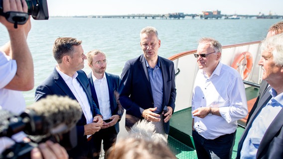 Olaf Lies (SPD), Marten Gäde (SPD), Klaus-Dieter Maubach, und Stephan Weil (SPD) unterhalten sich auf einem Schiff. © dpa Foto: Hauke-Christian Dittrich