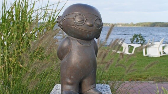 Die Bronzeskulptur eines Mainzelmännchens steht an einem See. Die Bronzeskulptur eines Mainzelmännchens steht an einem See. © Gemeinde Bad Zwischenahn Foto: Sabine Weiß