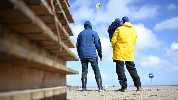 Eine Familie lässt bei schönem Wetter einen Flugdrachen am Nordseestrand fliegen. © Lars Klemmer/dpa Foto: Lars Klemmer/dpa