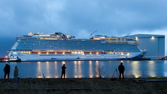 Menschen verfolgen die Überführung der Norwegian Bliss. © dpa-Bildfunk Foto: Mohssen Assanimoghaddam