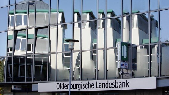 Die Fassade eines Nachbargebäudes spiegelt sich in der Glasfront der Oldenburgischen Landesbank in Nordhorn. © dpa-Bildfunk Foto: Friso Gentsch
