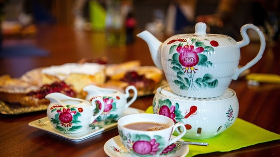 Geschirr mit der traditionellen Ostfriesischen Rose steht auf einem Tisch. © picture alliance/dpa Foto: Sina Schuldt