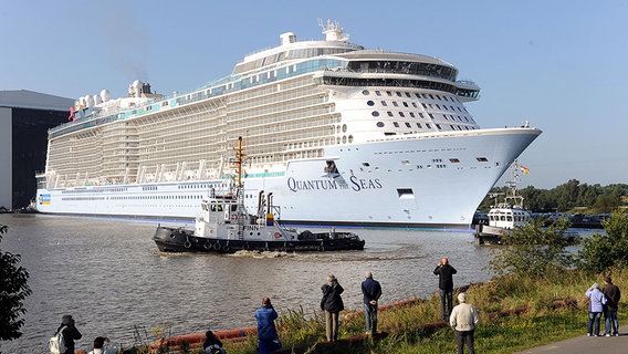 Zwei Schlepper fahren vor dem Kreuzfahrtschiff "Quantum of the Seas" aus der Meyer Werft in Papenburg. © dpa-Bildfunk Foto: Ingo Wagner