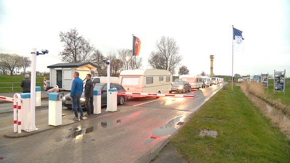 Camper stehen mit ihren Campingwagen an der Schranke des Campingplatz in Schillig. © NDR 