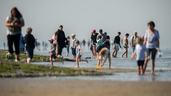 Urlauber sind bei schönem Wetter am Strand von Cuxhaven Döse. © dpa-Bildfunk Foto: Mohssen Assanimoghaddam/dpa