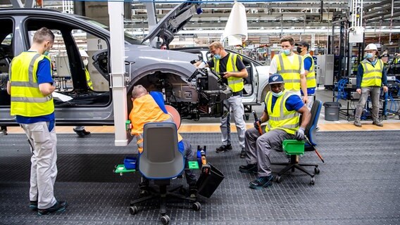 Mitarbeiter von VW arbeiten am ID.4. © picture alliance/dpa Foto: Sina Schuldt