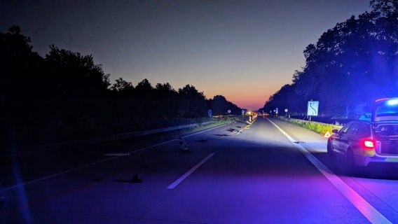 Ein Auto steht im Morgengrauen auf einer Autobahn. Mehrere Warnbaken wurden von einem Kleintransporter umgefahren. © Polizeiinspektion Cuxhaven 