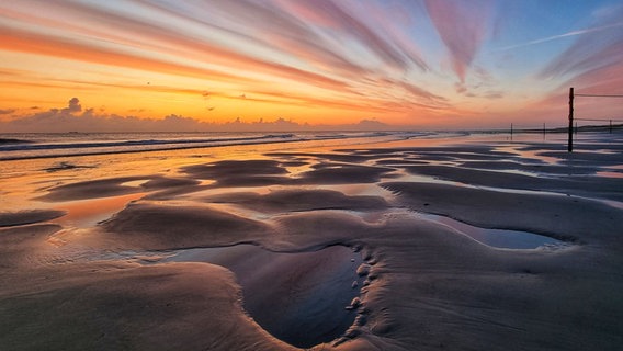 Die Sonne geht über einem Strand auf Wangerooge auf. © NDR Foto: Hans-Jürgen Grünewälder