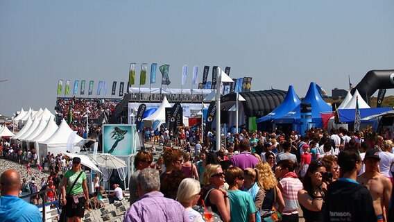 Auf dem Festivalgelände des White Sands Festivals sind neben Besuchern Tribünen, Zelte und Fahnen zu sehen. © White Sands Festival 