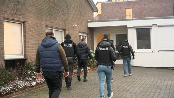 Beamte der Polizei gehen für eine Durchsuchung in ein Haus. © TV7News 