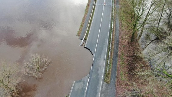 Eine Luftaufnahme zeigt eine Straße bei Haselünne von Hochwasser unterspült. © Nord-West-Media TV 
