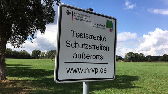 Auf einem Schild steht "Teststrecke Schutzstreifen außerorts". © NDR Foto: Hedwig Ahrens