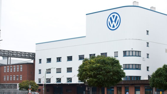 Das VW-Logo ist an einem Gebäude im Volkswagenwerk in Osnabrück zu sehen. © picture alliance / dpa Foto: Philipp Hülsmann