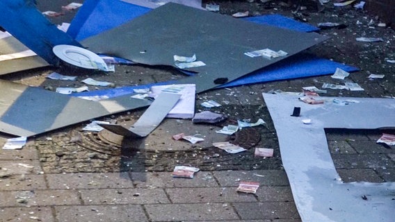 Geildscheine und Teile eines Geldautomaten liegen nach einer Sprengung auf der Straße. © Nord-West-Media TV 