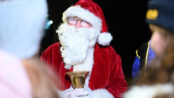 Das Bild zeigt einen als Nikolaus verkleideten Mann der Geschenke in Weener verteilt. © dpa-Bildfunk 