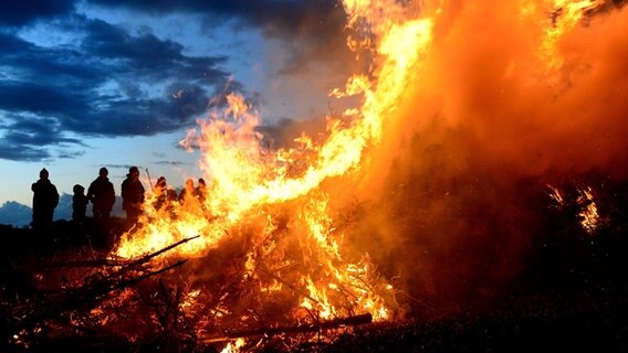 Menschen stehen neben einem Osterfeuer. © picture alliance/dpa/Maurizio Gambarini Foto: Maurizio Gambarini