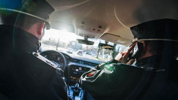 Innenansicht eines Streifenwagens, in dem zwei Polizisten sitzen. © NDR Foto: Julius Matuschik