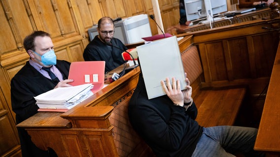 Der 21-jährige Angeklagte des sogenannten "Armbrustschützen-Prozesses" sitzt mit seinen Anwälten Manar Taleb (r) und Thomas Domanski (l) im Gerichtssaal in Bremen. © picture alliance/dpa | Sina Schuldt Foto: Sina Schuldt