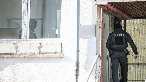 Ein Polizeibeamter durchsucht während einer Razzia eine Moschee in Villingen-Schwenningen. © picture alliance/dpa/Schwarzwälder Bote | Marc Eich Foto: Marc Eich